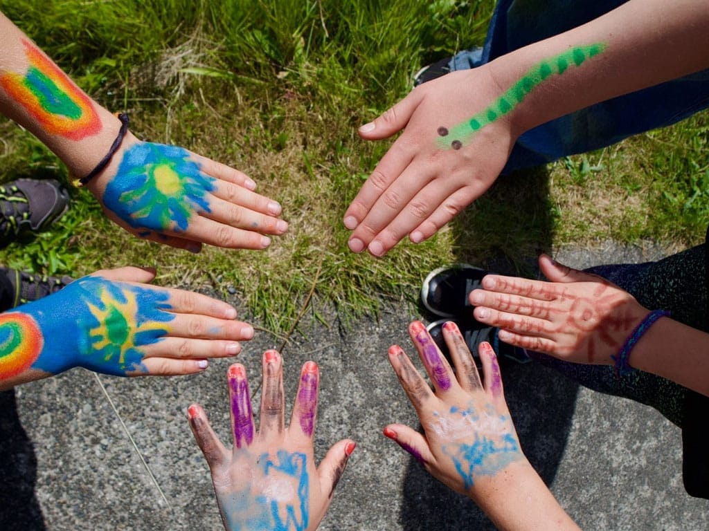 Hands that have been painted with designs during summer camp. Photo by Kaiya C