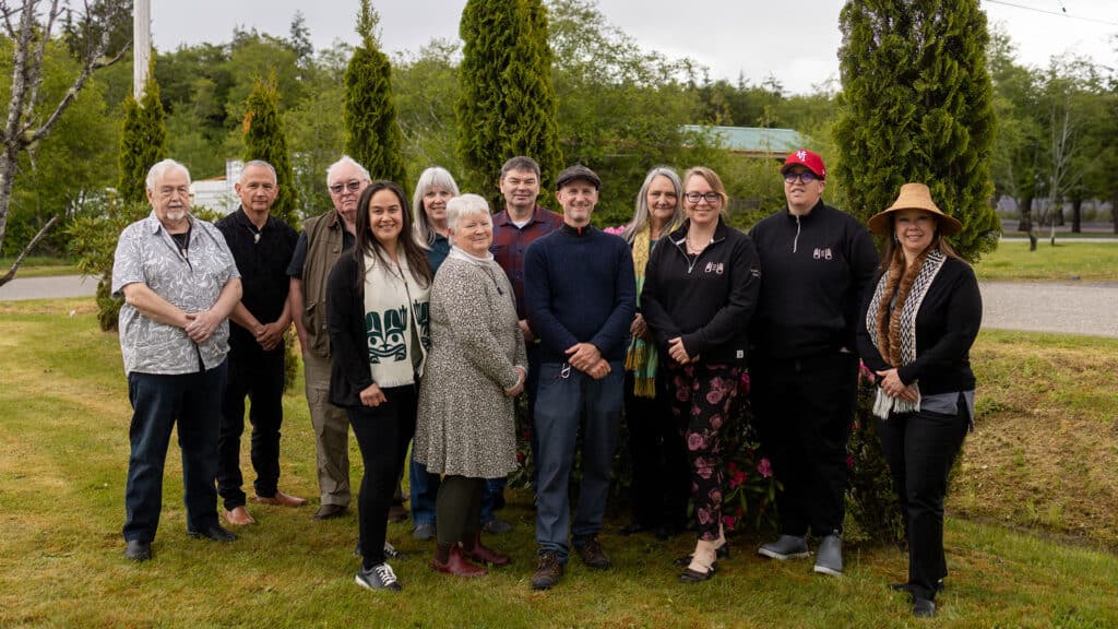 The 2026 Gwaii Trust Society board of directors, standing in front of a green hedge.