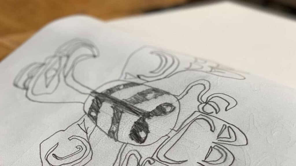 Open page of a child's sketchbook, showing the drawing of a Haida formline eagle.