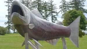 The "Spirit of Sandspit" sculpture by Lon Sharp. It is a large sculpture of a salmon made of copper, wood, and other materials.