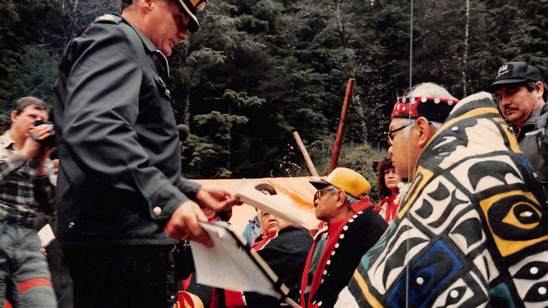 An RCMP officer serves paperwork to Tsinni Adolphus Marks, an elder who stood the line