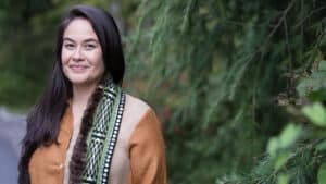 Valine Brown stands in front of a forest