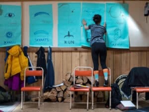 A person puts up Haida language translations on a wall